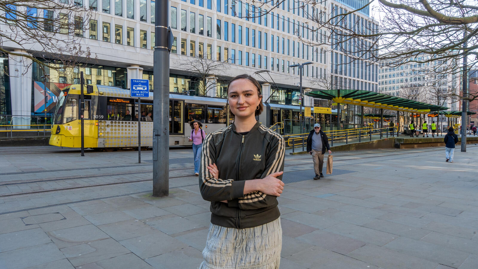 A picture of Grace Green stood in front of a tram station in central Manchester, UK