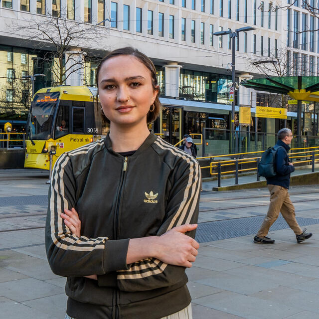 A picture of Grace Green stood in front of a tram station in central Manchester, UK